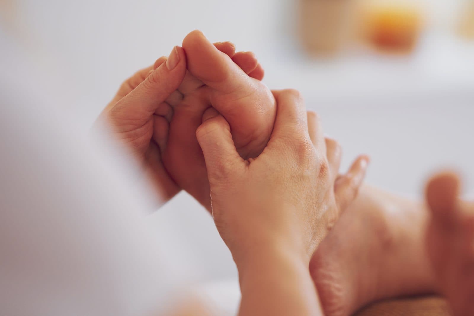 Hands applying gentle pressure to a client's hand