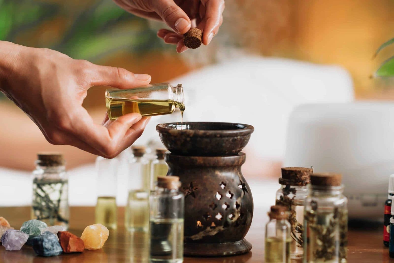 Warm oil poured for an Ayurvedic treatment among herbs and bottles