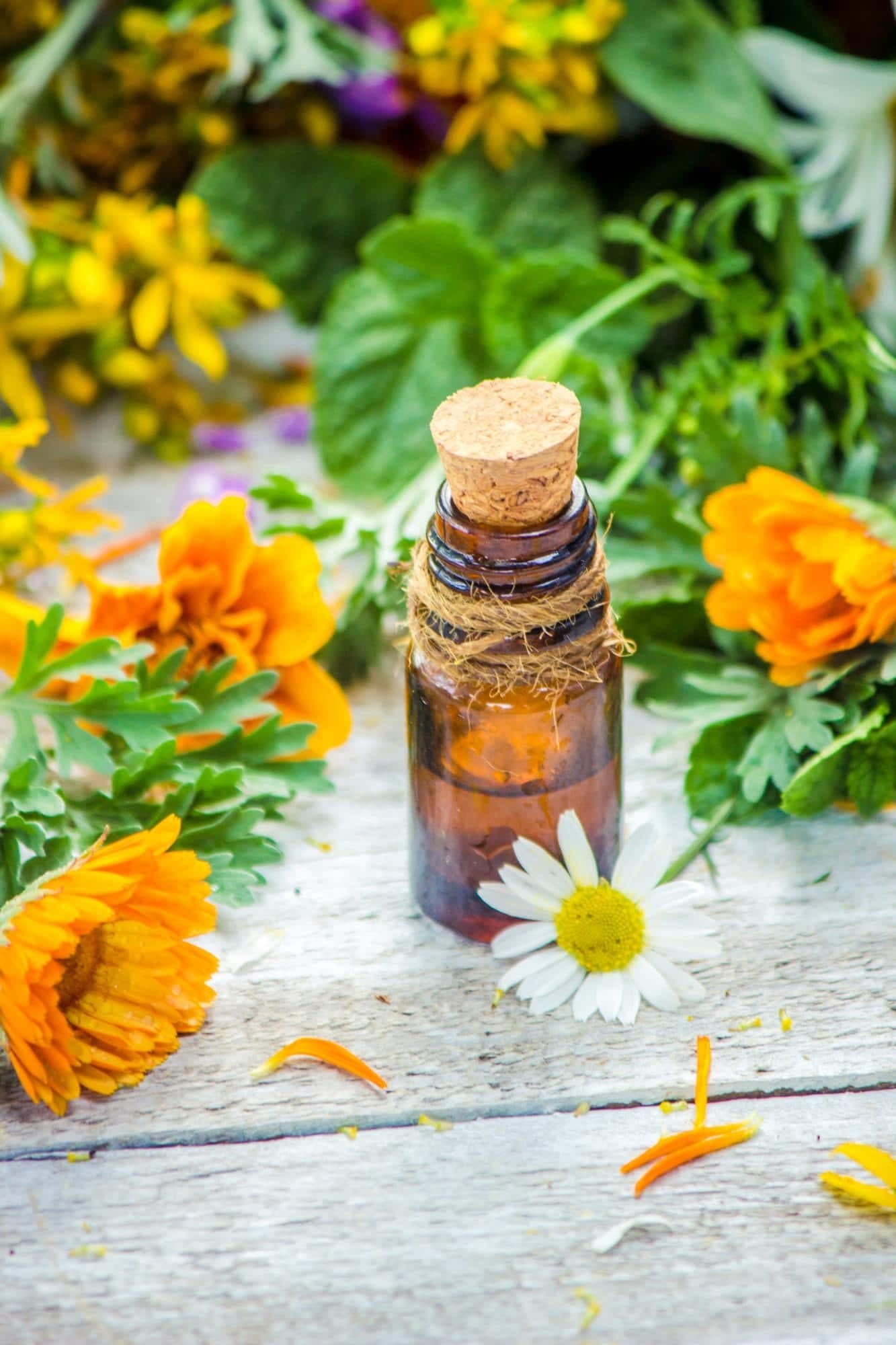 Flower essence bottle among fresh marigolds