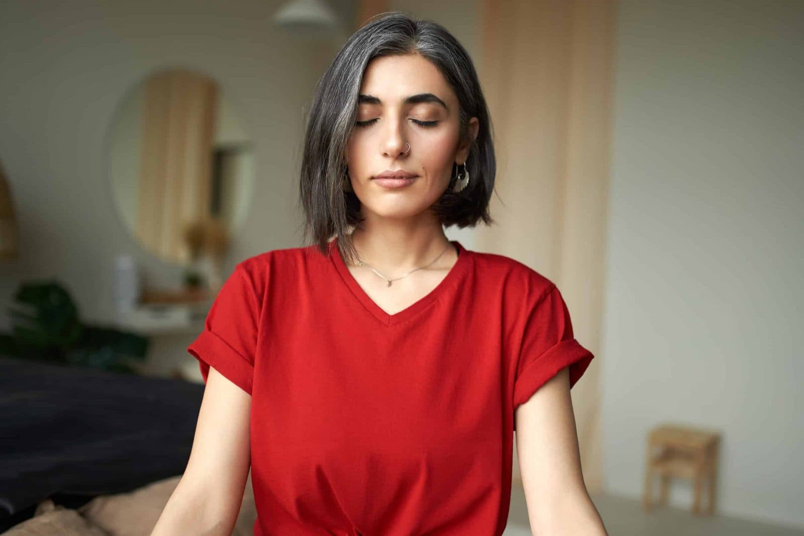 Woman sitting upright, eyes closed, breathing slowly