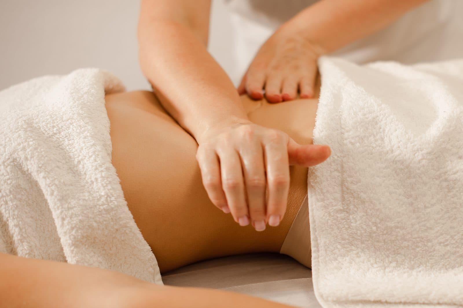 Therapist massaging a client's abdomen during a wellness session
