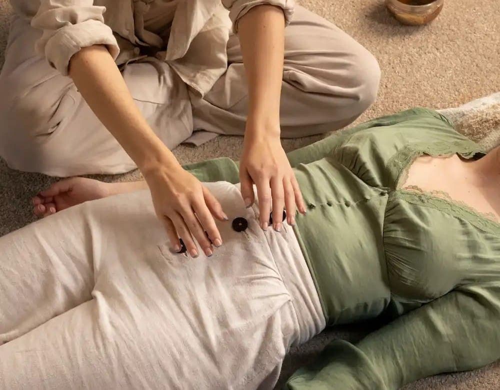 Practitioner's hands working on a client's abdomen
