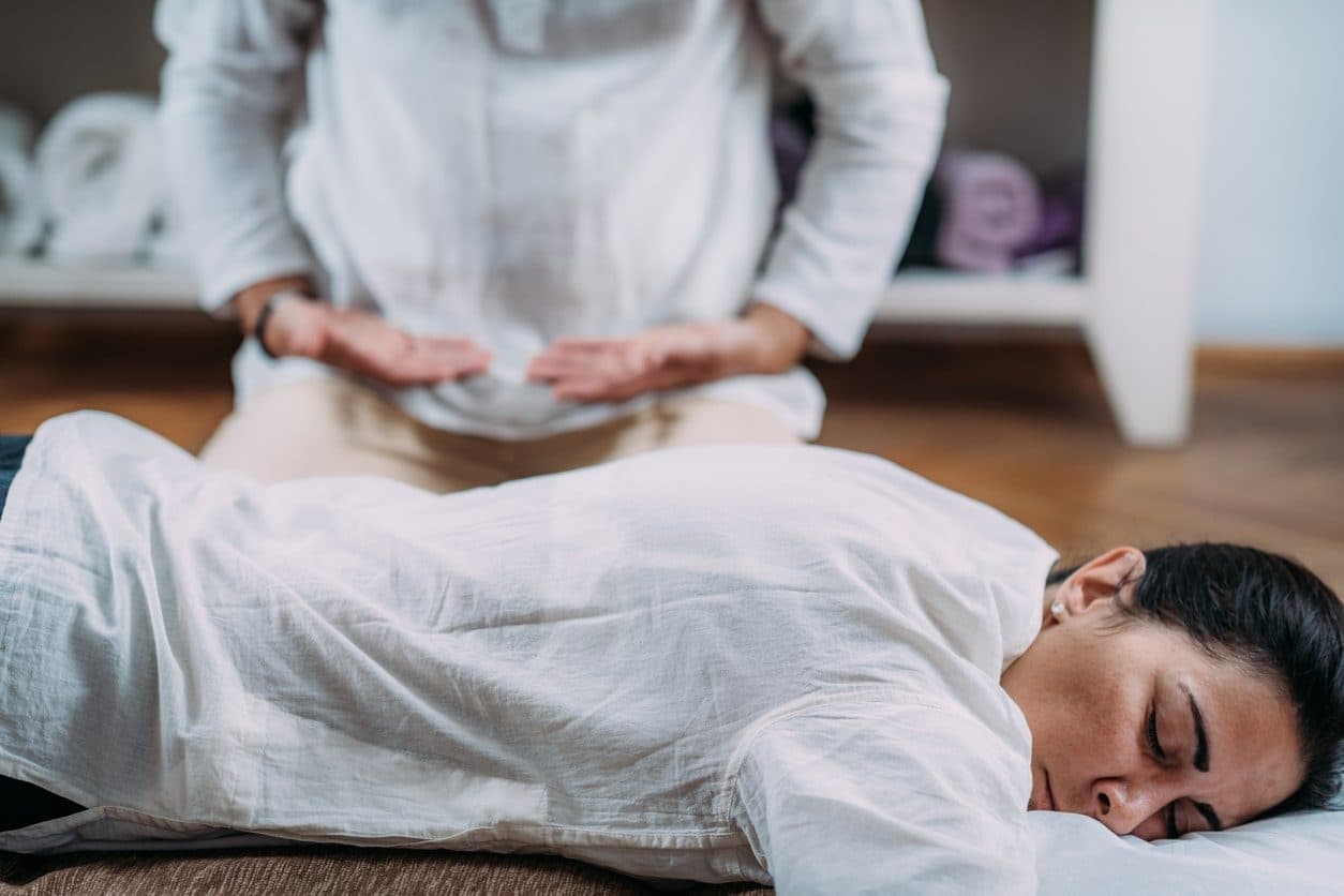 Close-up of hands pressing gently on the belly during an abdominal session