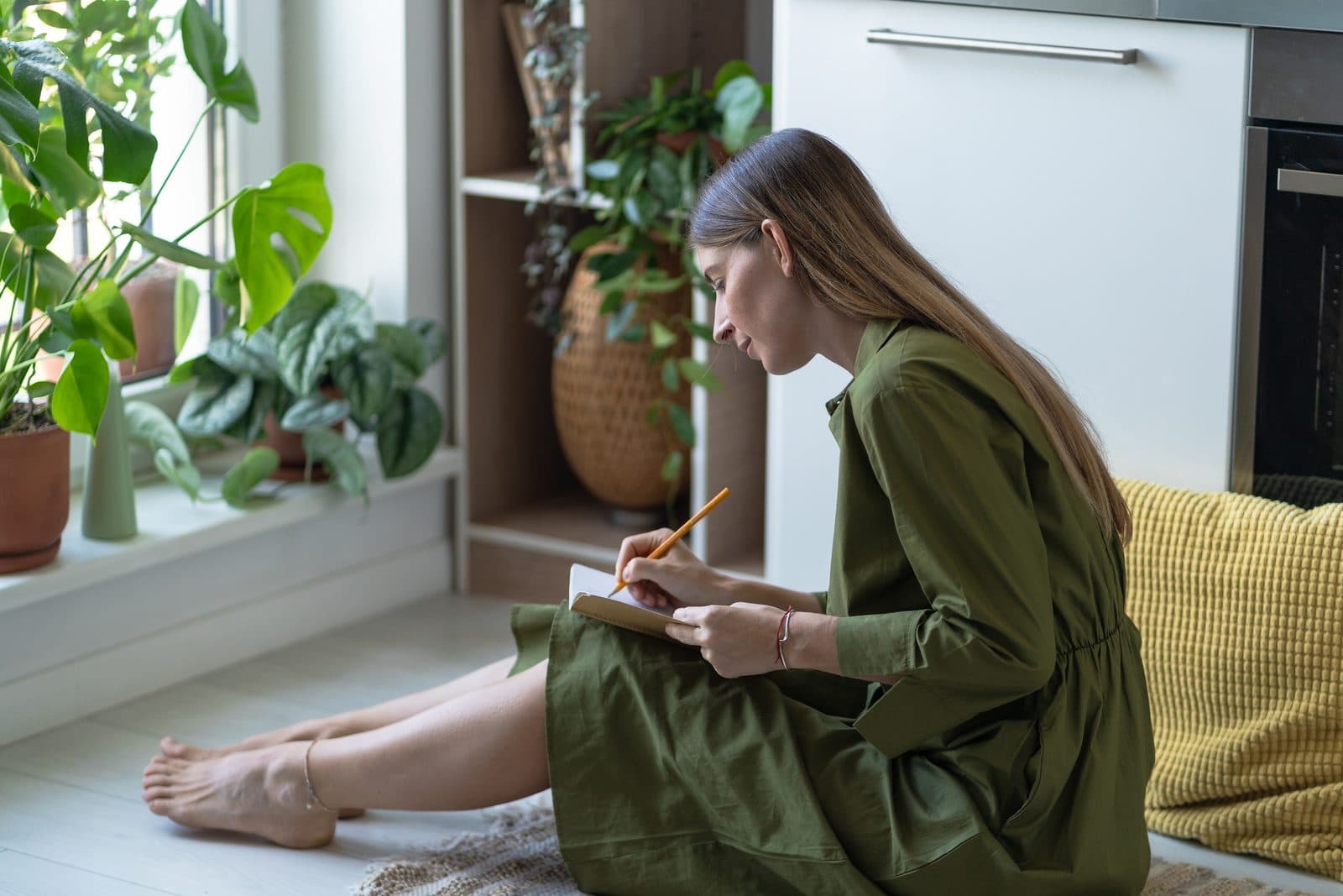 Woman writing in her journal, sitting calmly on the floor