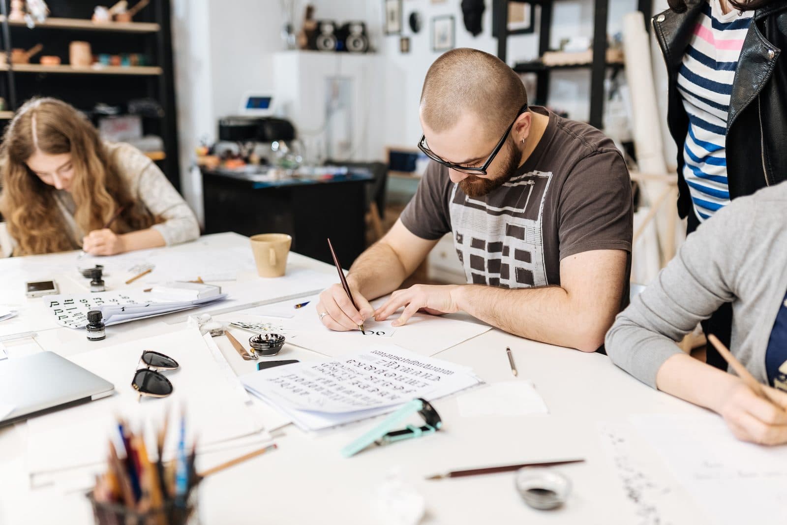 Participants drawing and writing side by side at a studio table
