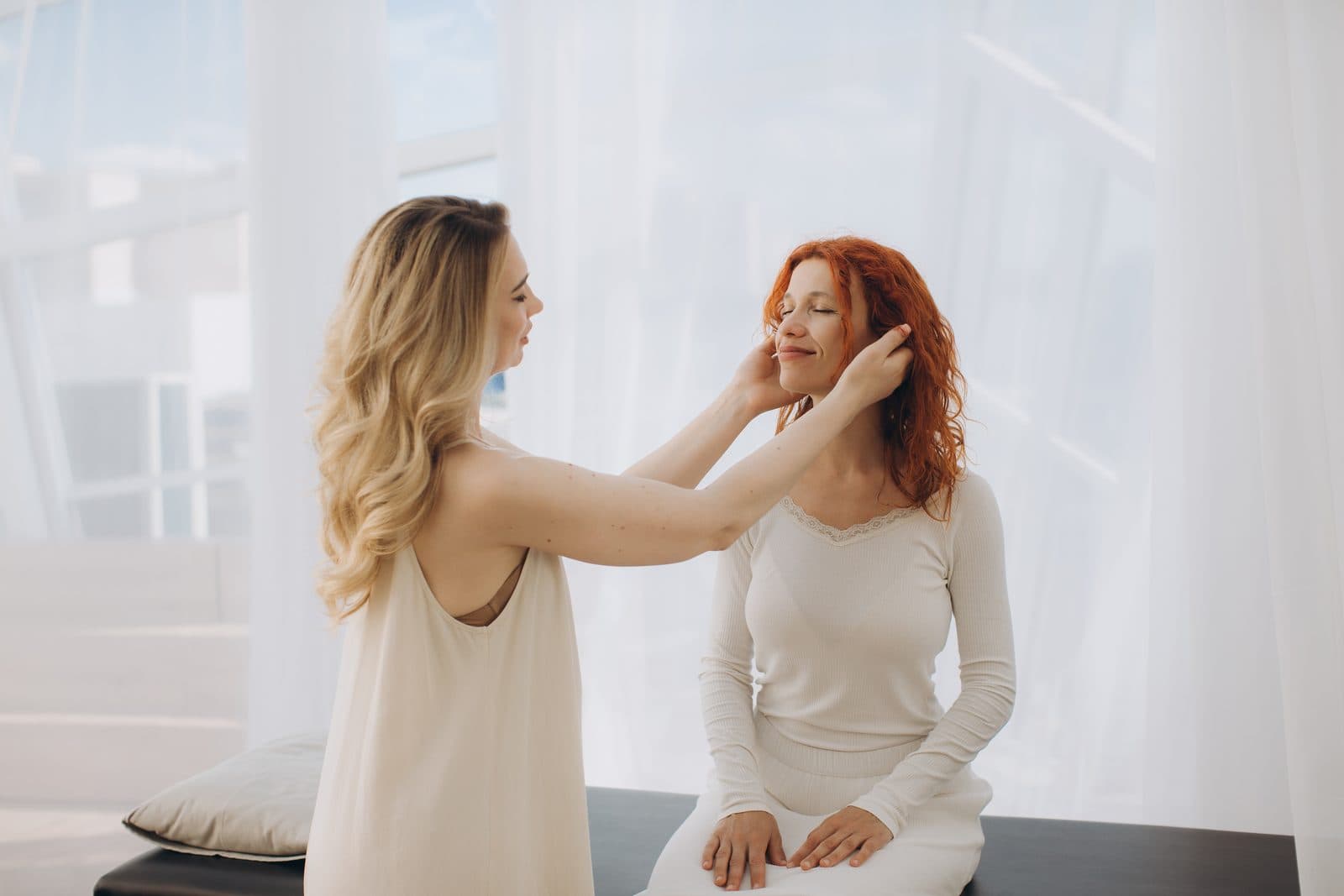Practitioner working with her hands near a relaxed client during an energy healing session