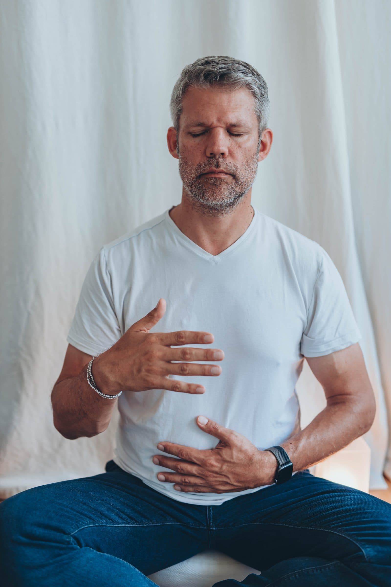 Man resting a hand on his chest, breathing slowly