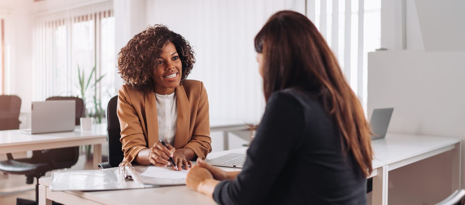 Coach and client in conversation at a desk