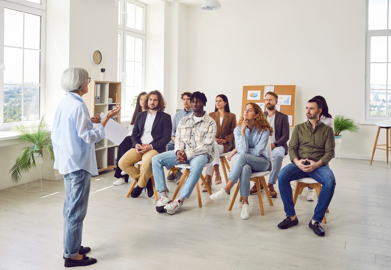 Instructor speaking to a seated group in a bright studio