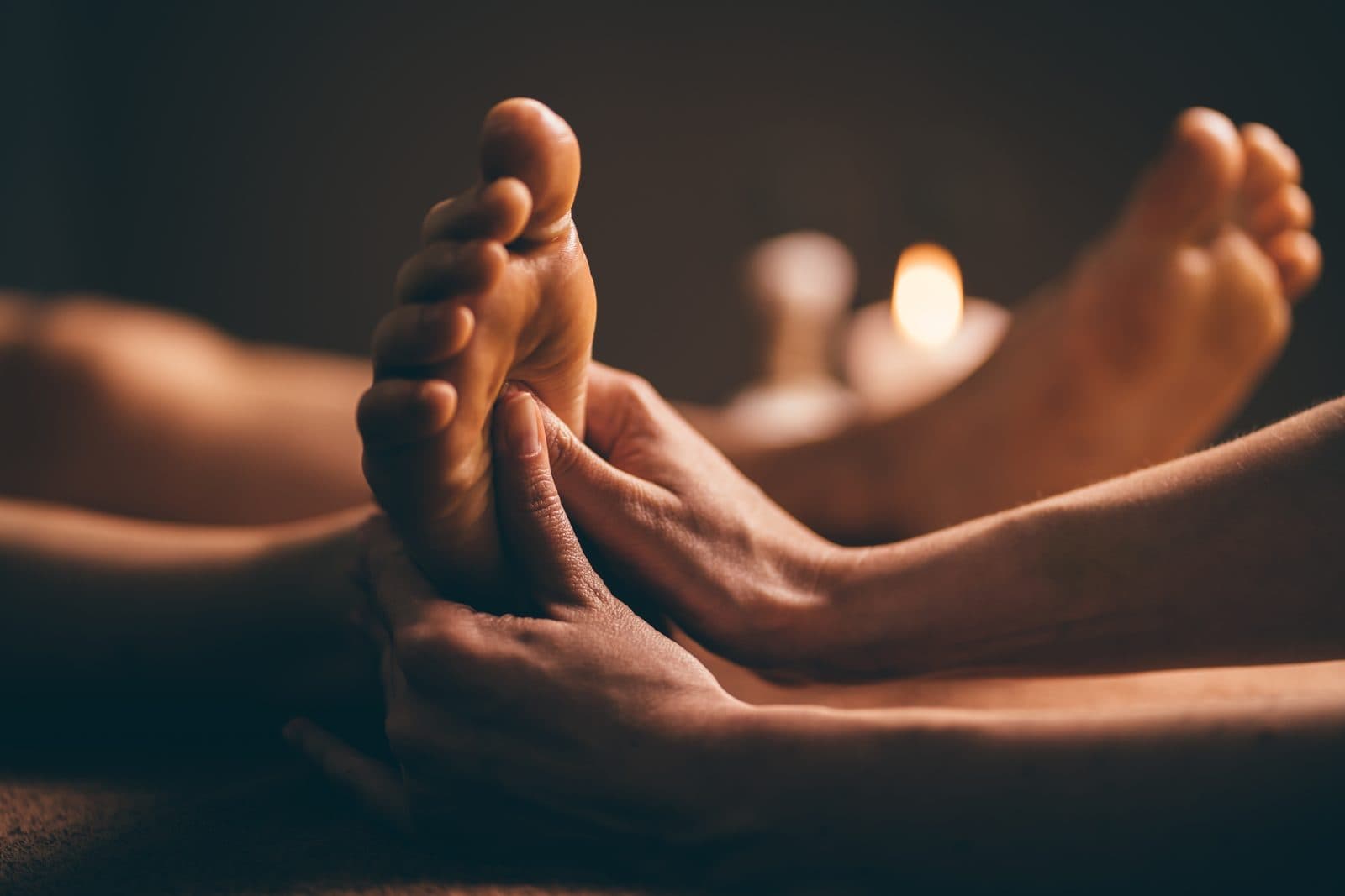 Foot reflexology session in soft candlelight