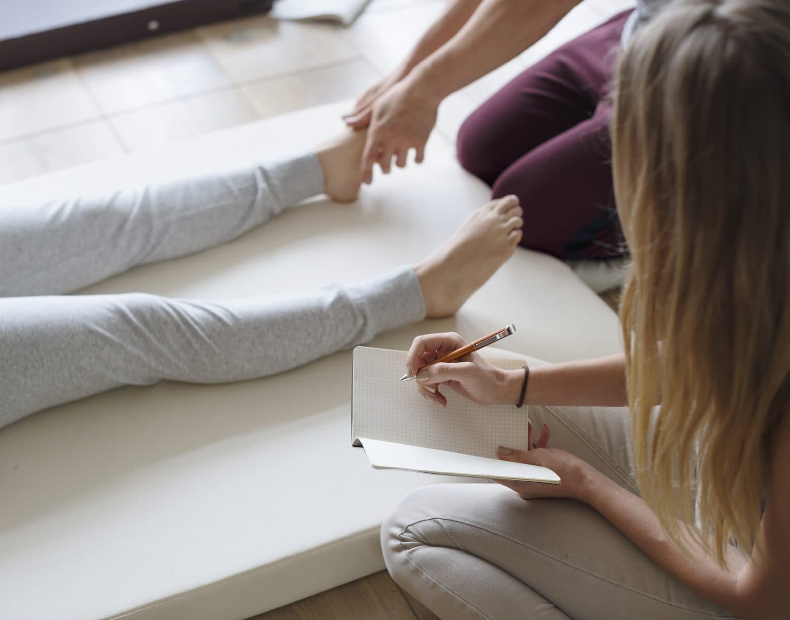 Student taking notes during a foot reflexology practice