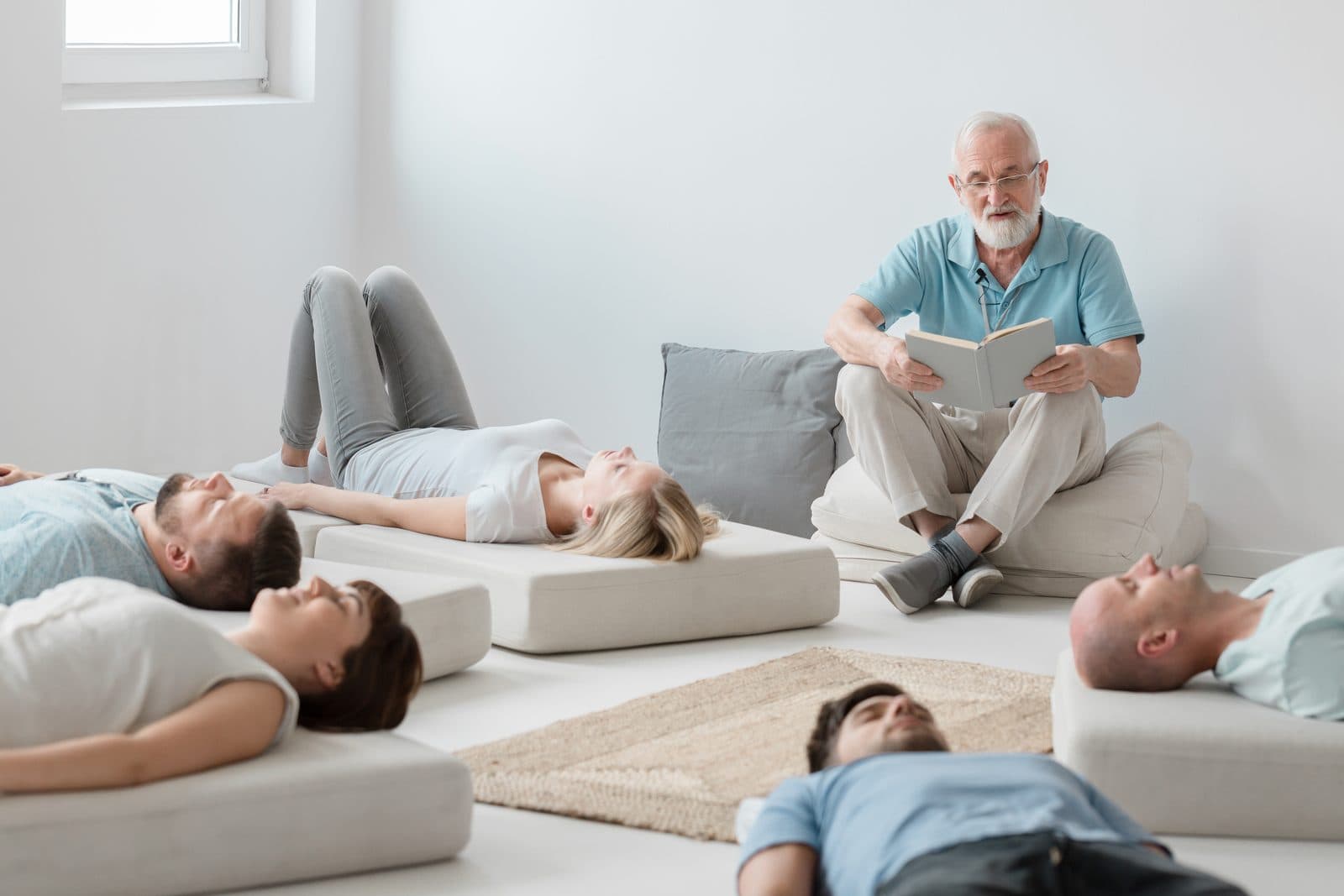 Small group resting on floor cushions while the facilitator guides the session