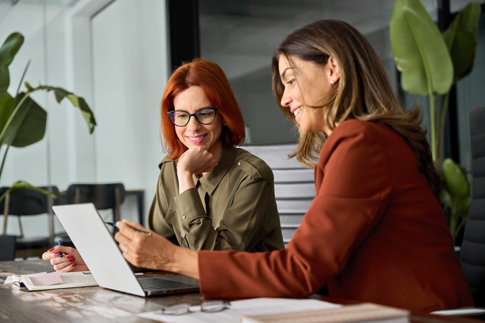 Two women reviewing notes on a laptop together