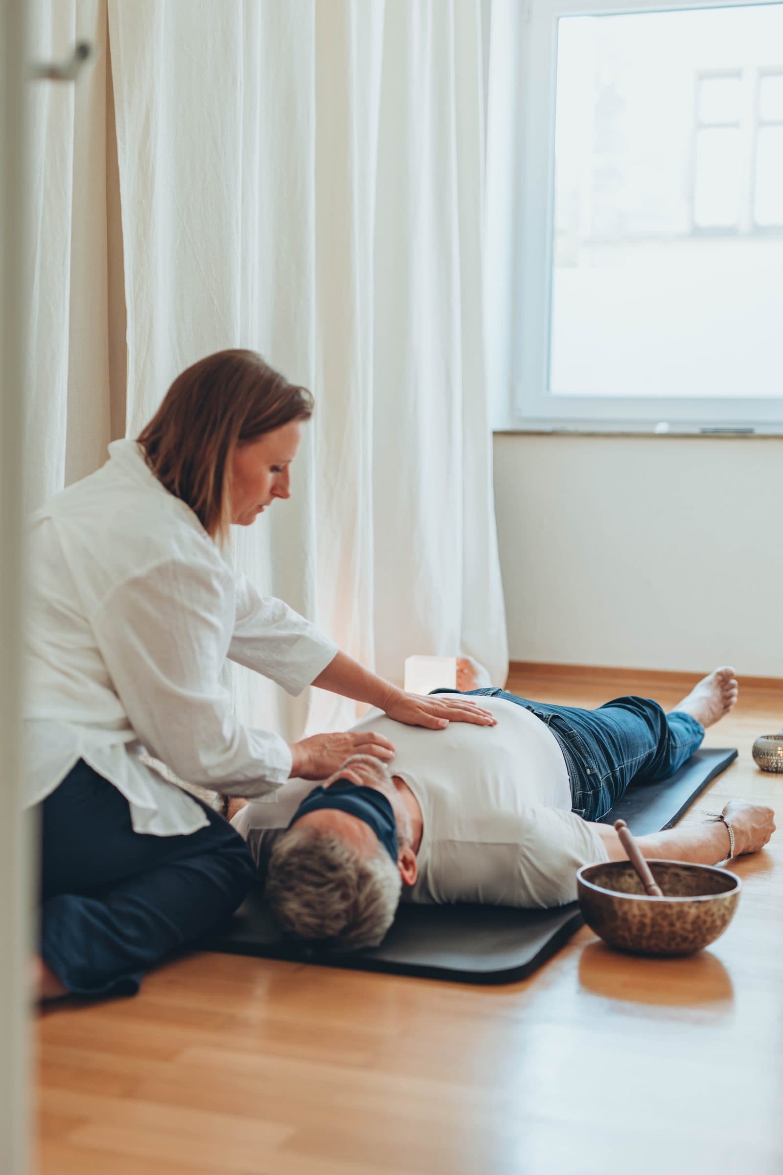 Practitioner placing her hands on a client's torso during a Reiki session